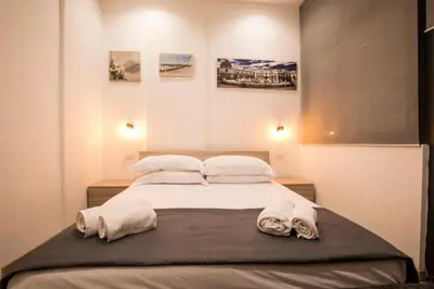 a bedroom with a large bed with towels on it at Sammartino suite in Palermo