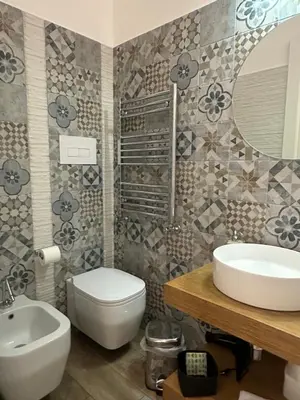 a bathroom with a sink and a toilet and a mirror at Sammartino suite in Palermo