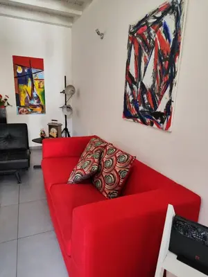 a red couch in a living room with paintings at House Il Conte in Palermo