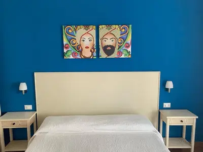 a bedroom with a white bed and two nightstanduments at Villa Ancora B&B in San Vito lo Capo