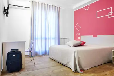 a bedroom with a bed and a red wall at Ai Gradini Affittacamere in Castellammare del Golfo