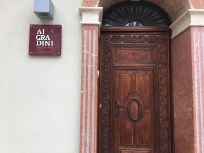 a wooden door on a building with a sign above it at Ai Gradini Affittacamere in Castellammare del Golfo