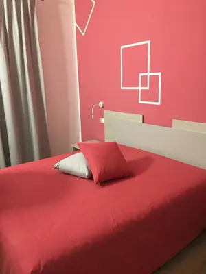 a bedroom with a red bed with a red wall at Ai Gradini Affittacamere in Castellammare del Golfo