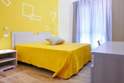 a yellow bedroom with a bed with a yellow blanket at Ai Gradini Affittacamere in Castellammare del Golfo