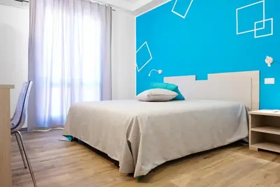 a bedroom with a bed with a blue wall at Ai Gradini Affittacamere in Castellammare del Golfo