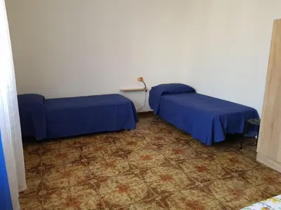 two beds in a room with blue sheets at Bilocale Mini Very in San Vito lo Capo