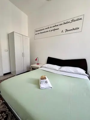 a bedroom with a green bed with a sign on the wall at Liolà Home #Teatro Massimo in Palermo