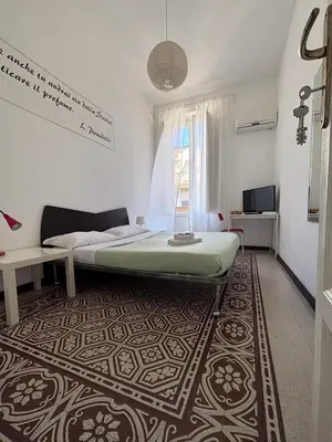 a bedroom with a bed and a rug at Liolà Home #Teatro Massimo in Palermo