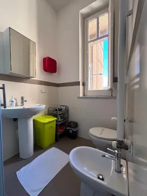 a bathroom with a sink and a toilet and a window at Liolà Home #Teatro Massimo in Palermo