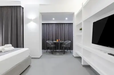 a hotel room with a bed and a television and a table at Suite Palermo Apartment in Palermo