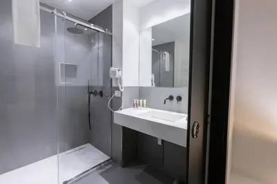 a white bathroom with a sink and a shower at Suite Palermo Apartment in Palermo