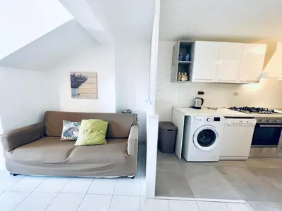a living room with a couch and a washing machine at Villino Addaura in Lido di Mondello
