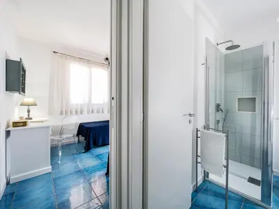 a bathroom with a glass shower and a table at Spuma di Mare - Riccio in San Vito lo Capo