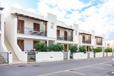 a row of white apartment buildings on a street at Case Vacanza appartamenti Trinacria in San Vito lo Capo