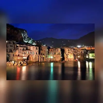 a view of a city at night with the water at L'angolo di Rosa in Campofelice di Roccella