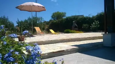 a patio with two chairs and an umbrella at Antico Rustico in Scopello