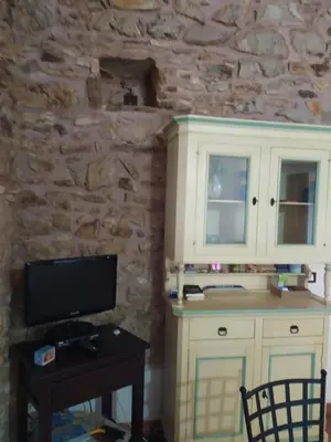 a room with a tv and a cabinet and a table at Antico Rustico in Scopello