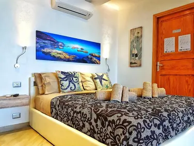 a bedroom with a bed and a couch at Brezza Marina Guesthouse in Cefalù