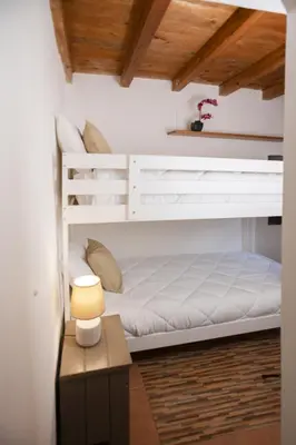 a bedroom with a bunk bed and a table with a lamp at Montesanto 13 in Palermo