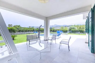 a patio with chairs and a table and a view at Villa Arvilla with Private POOL in Campofelice di Roccella