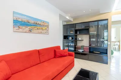 a red couch in a living room with a painting at Villa Arvilla with Private POOL in Campofelice di Roccella