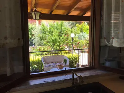 a window with a view of a chair sitting on a balcony at Stunning Sicilian Villa in Carini