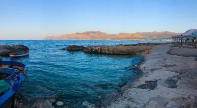 a body of water with two boats on the shore at Stunning Sicilian Villa in Carini