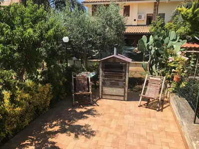 a patio with two chairs and a grill in a yard at Stunning Sicilian Villa in Carini