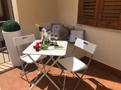 a white table with wine glasses and flowers on it at Coral sea in San Vito lo Capo