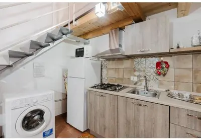 a kitchen with a sink and a washing machine at La casa di Anita nel cuore di Segesta in Calatafimi