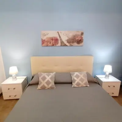 a bedroom with a large bed with two night stands at La casa di Anita nel cuore di Segesta in Calatafimi