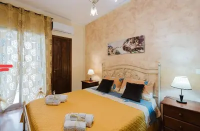 a bedroom with a large yellow bed with two pillows at La casa di Anita nel cuore di Segesta in Calatafimi