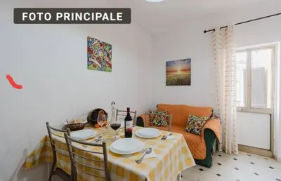 a dining room with a table and a couch at La casa di Anita nel cuore di Segesta in Calatafimi