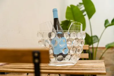 a wine glass with a bottle of wine on a table at Casa Relax Mondello in Mondello