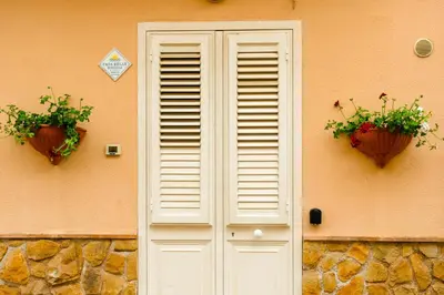 a white door with two potted plants on a building at Casa Relax Mondello in Mondello
