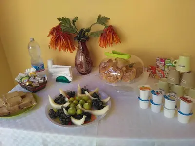 a table with a plate of food and a vase with flowers at La Casa Gialla in Trabia