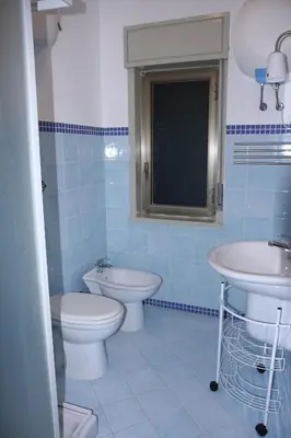 a blue bathroom with a toilet and a sink at La Casa Gialla in Trabia