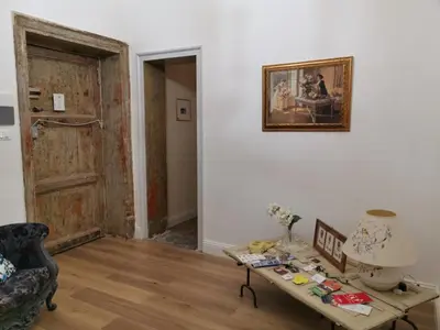 a living room with a table and a picture on the wall at Artisan Maison Palermo in Palermo