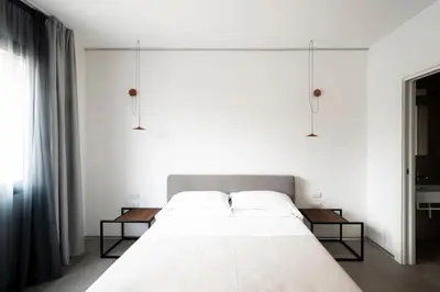a bedroom with a large white bed with two tables at Alkamuri Posh Hotel e Spa in Alcamo
