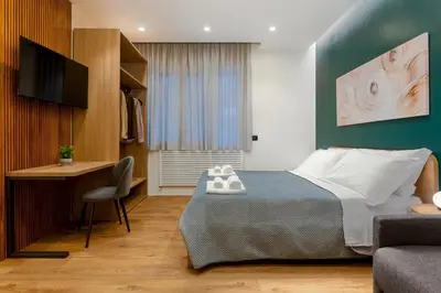 a bedroom with a bed and a desk and a television at Quinto Stabile Rooms&Suite in Palermo