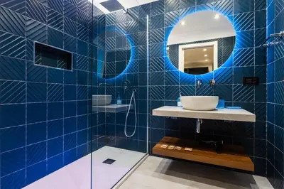 a blue tiled bathroom with a sink and a mirror at Quinto Stabile Rooms&Suite in Palermo
