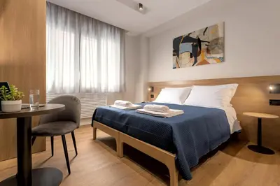 a hotel room with a bed and a table and a chair at Quinto Stabile Rooms&Suite in Palermo