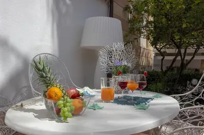 a white table with fruit and wine glasses on it at Villa Degli Ulivi Flora in Mondello