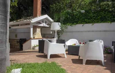 a group of white chairs sitting on a patio at Villa Degli Ulivi Flora in Mondello