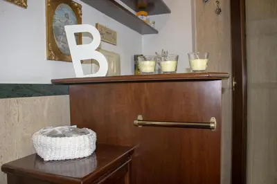 a bathroom with a wooden door and a shelf with candles at Villa Degli Ulivi Flora in Mondello