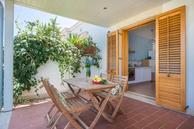 a wooden table and chairs on a patio at Calarossa Seaview by Wonderful Italy in Terrasini