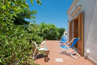 two blue chairs sitting on a brick patio at Calarossa Seaview by Wonderful Italy in Terrasini