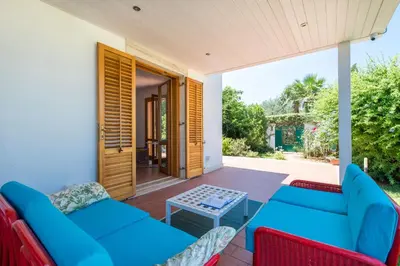 a patio with blue couches and a table at Calarossa Seaview by Wonderful Italy in Terrasini