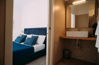 a bedroom with a bed with a sink and a mirror at The Lighthouse in Trappeto