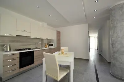 a kitchen with a white table and a white chair at Villa Bianca e Villa Arancio in Alcamo